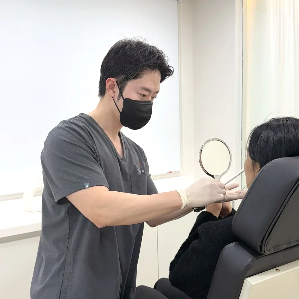 나의계절의원 울산 대표원장이 거울을 보며 얼굴선과 탄력 상태를 상담하는 모습